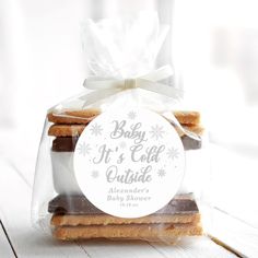 some cookies in a clear bag with a white ribbon around it's edge and the label says baby it's cold outside