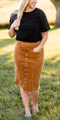 The Farrah Rust Corduroy Skirt is an Inherit Design that is made with a fine corduroy texture that is extra stretchy. This midi skirt features button details down the front of the skirt with three functioning buttons at the top. There are functioning patch-style pockets on the front and a raw hem detail that finishes off the skirt. This midi skirt is super stretchy so you will feel comfortable and on-trend without compromising! Style: 3 functioning top buttons, raw hem detail, stretchy, no slit Corduroy Skirt Plus Size, Rust Corduroy Skirt Outfit, Rust Corduroy Skirt, Orange Skirt Outfit Fall, Cardigan Skirt Outfit, Corderoy Skirt, Orange Skirt Outfit, Corduroy Skirt Outfit, Rust Cardigan