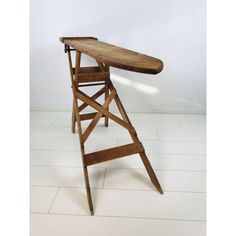 an ironing board on top of a wooden chair in the middle of a room