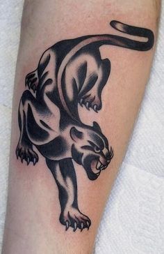 a black and white tattoo of a panther on the arm