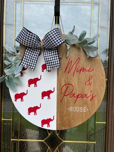 a door hanger decorated with red elephants and black gingham bows is hanging on the front door