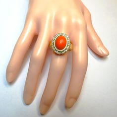 Italian Red Coral White Diamond 14k Yellow Gold Ring featuring a 3 carat Italian Red Coral Cabachon surrounded by half a carat of sparkling White Diamonds. Ring size: 7.  All photo's taken in daylight so you can see the color of the coral which is very dense and even in color. The ring measures 18mm long x 15 mm wide.   The oval carved red coral gem is 12 mm x 8 mm.   Each 2mm diameter white diamond is class G-H VS2-SI. Hallmarked 14k inside the band. Weight: 8 grams.  Ring ships fully insured with signature on delivery and gift wrapped. Red Oval Diamond Ring, Victorian Oval Red Diamond Ring, Victorian Style Red Oval Diamond Ring, Oval Diamond Ring For Collectible, Antique Oval Red Diamond Ring, Antique Red Oval Diamond Ring, Oval Diamond Ring For Collectors, Heirloom Red Oval Diamond Ring, Red Oval Diamond Ring With Accents