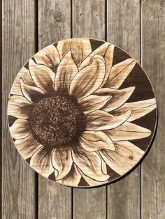 a wooden plate with a sunflower painted on it