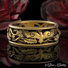 a gold wedding band with leaves and vines on the side, sitting in front of a black background