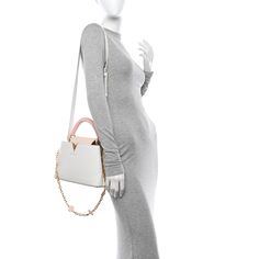 This is an authentic LOUIS VUITTON Taurillon Flower Chain Capucines BB in White. This petite tote is featured in textured taurillon calfskin leather in white and light pink. The bag features a pink leather hand carry top handle, a pale pink flap that can be tucked in or left out, gold hardware, and a leather-trimmed LV logo. The partitioned interior is lined in white calf leather with a patch pocket. Lv Logo, Flower Chain, Left Out, Pink Leather, Authentic Louis Vuitton, Pale Pink, Leather Trims, Gold Hardware, Patch Pocket