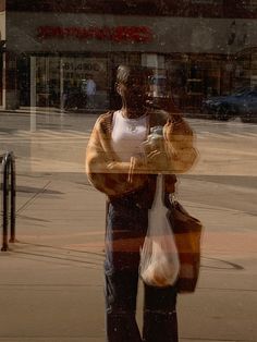 a man is standing on the sidewalk with his cell phone in hand and looking at something