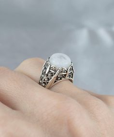 Make a statement with this exquisite Handmade Filigree Art Moonstone Gemstone Women Silver Cocktail Statement Ring. Crafted with intricate details, this ring features a mesmerizing 10 mm cabochon round-cut moonstone gemstone, set in an elegant silver band measuring 0.55 inches / 13.50 mm in length and width. This stunning ring showcases the beauty of filigree, an ancient art form that originated in Mesopotamia and Anatolia. It comes with a silver polish cloth and luxurious gift box, making it th Intricate Design Moonstone Jewelry, Bohemian Cabochon Moonstone Ring, Bohemian Round Cabochon Moonstone Ring, Bohemian Crystal Ring With Moon Phase, Vintage Round Cabochon Moonstone Ring, Vintage Cabochon Moonstone Ring, Mystical Round Cabochon Jewelry, White Moon Phase Crystal Ring, Vintage Moon Phase Jewelry