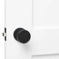 a black door handle on a white door with a round knob in the center and bottom