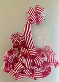 a red and white christmas wreath hanging on the wall