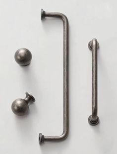 an assortment of metal handles and knobs on a white surface