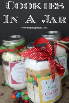 three jars filled with cookies in a jar on top of a table next to candy