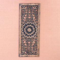 a wooden panel with an intricate design on the outside and inside, hanging on a wall