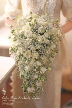 a bride holding a bouquet of white flowers