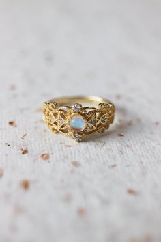 Sonia Moonstone Floral Gold Lace Filigree 18K Gold Vermeil Ring features moonstone in the centre, accented by lace filigree on the sides. It is similar to Monique Moonstone Ring in our shop, but the details of the ring are different. This is an adjustable ring, it comes in one size only and fits US ring size 5 to 8. ◊ 18K Gold Vermeil ◊ Adjustable Ring ◊ Sold in ONE SIZE only ◊ Fits US ring size 5 to 8 ◊ Lab Moonstone and cubic zircons ◊ Delivered in our signature royal blue box, it makes the pe Elegant Gold Moon-shaped Moonstone Ring, Celestial Style Moonstone Promise Ring, Ethereal 14k Gold Ring Jewelry, Ethereal Gold Ring For Anniversary, Ethereal Gold Rings For Anniversary, Ethereal 14k Gold Wedding Rings, Ethereal Gold Anniversary Rings, Gold Celestial Moonstone Ring In 14k, Gold Opal Gemstone Promise Ring