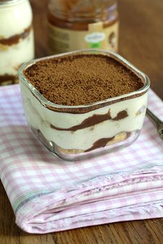 a dessert in a glass dish on top of a pink and white checkered napkin