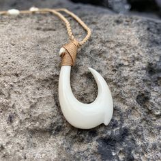 a white horn necklace on a rock