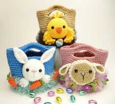 four crocheted baskets with stuffed animals and candy candies around them on a white surface