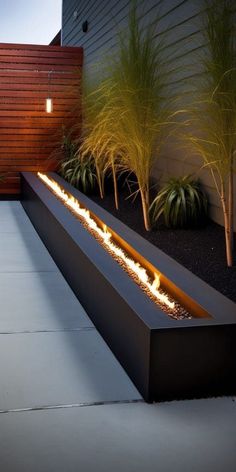 an outdoor fire pit in the middle of a patio with plants and lights on it