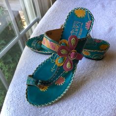 These Sandals Are Stunning!!! Done In All Leather Upper In A Boho Style In In Teal W/ Stamped Leather Flowers In Colors Of Pink And Yellow And Neutral Color Stems. One Main Strap That Comes Over Top Of Foot And Buckles W/ Strap On Other Side That Makes A Flower ( Which Has Green And Blue Beading. Thong Style With Toe Strap. Decorative White Stitching All Around Grated Black Sole. No Real Wear. Small Discoloration On Left Buckle. Closed Toe Turquoise Sandals For Summer, Turquoise Closed Toe Sandals For Summer, Spring Flip Flops With Removable Insole And Toe Post, Blue T-strap Sandals For Summer, Blue Open Toe T-strap Sandals For Spring, Leather T-strap Flip Flops For Spring, Hand Painted Open Toe Sandals For Spring, Casual Hand Painted Sandals For Summer, Casual Hand Painted Leather Sandals