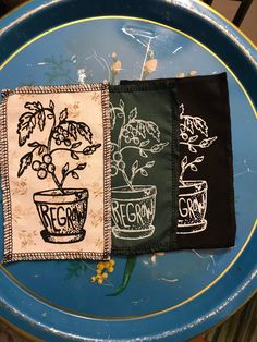 three potted plants on black and white napkins sitting on top of a blue plate