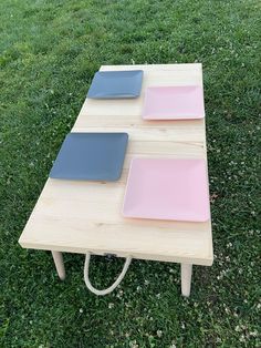 three plates sitting on top of a wooden table in the middle of a grass field