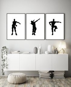 three black and white silhouettes of soccer players on the wall in a living room