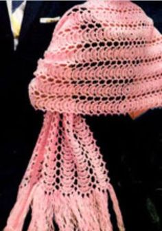 a pink crocheted hat with tassels and a man in a suit