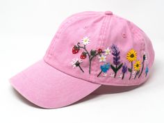 This hand embroidered flower baseball cap is a one-of-a-kind accessory that combines style and comfort. The cap is crafted from high-quality material, ensuring durability and comfort. The intricate floral design is hand-embroidered, giving each cap a unique touch and making it a standout piece. Whether you're running errands or enjoying a day outdoors, this cap will keep the sun out of your eyes in style. Flower is 100% hand embroidered on a 100% cotton wash baseball cap. Hat is one size fits al Spring Cotton Snapback Cap, Pink Embroidered Logo Baseball Cap, Spring Curved Visor Adjustable Trucker Hat, Spring Adjustable Baseball Cap With Curved Visor, Spring Adjustable Trucker Hat With Curved Visor, Spring Adjustable Snapback Hat With Curved Visor, Adjustable Curved Visor Baseball Cap For Spring, Embroidered Summer Trucker Hat With Curved Bill, Custom Embroidered Summer Hats With Adjustable Fit