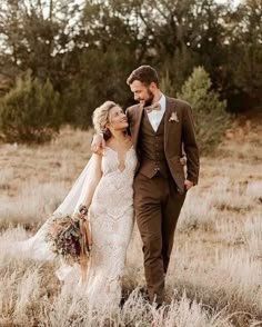 a bride and groom are walking through the grass