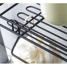 a close up of an oven rack with a white object in the middle and a cup on top