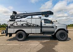 a truck with a crane on the back parked in a parking lot