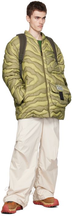 DIST-certified down-filled quilted nylon ripstop jacket. Graphic pattern throughout. · Stand collar · Zip closure · Flap pockets and seam pockets · Logo patches at front · Text embroidered at back · Nylon longue saison lining Part of the Moncler x Salehe Bembury collection. Supplier color: Green Fill: 90% goose down, 10% goose feather. Green Puffer Jacket With Pockets For Outdoors, Green Down Puffer Jacket With Pockets, Green Quilted Jacket With Pockets For Outdoor, Quilted Nylon Long-sleeved Parka, Quilted Nylon Parka With Long Sleeves, Outdoor Duck Down Puffer Jacket With Pockets, Outdoor Nylon Quilted Jacket With Pockets, Long Sleeve Nylon Puffer Jacket With Pockets, Outdoor Quilted Nylon Jacket With Pockets