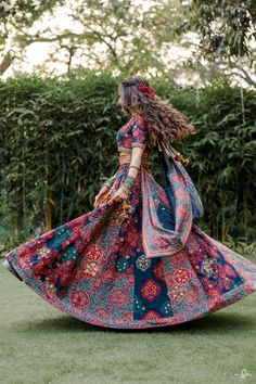 a woman in a colorful dress is walking through the grass