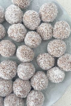 a bowl filled with sugar covered donuts on top of a table