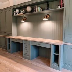 an empty room with two desks and some bookshelves on the wall above them