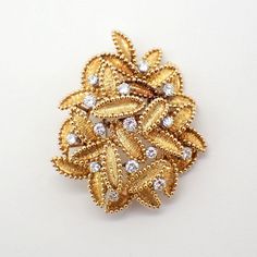 Vintage 18k (.750) yellow gold combination of a brooch and pendant, featuring figural leaf cluster, embellished with Diamonds. 15 Diamonds are approx. 1.4ctw, VS-SI clarity, color G-H-I. This majestic brooch or pendant is 50 mm tall, 41 mm wide and weighs 27.1 grams. EA3452 Gold Diamond Pendant Brooches, Gold Diamond Pendant Brooch, Yellow Gold Diamond Brooches Fine Jewelry, Diamond Yellow Gold Brooches Fine Jewelry, Yellow Gold Diamond Brooch Fine Jewelry, Fine Jewelry Diamond Brooch In Gold, Elegant Gold Brooches With Diamond Accents, Yellow Gold Diamond Brooch In Fine Jewelry Style, Exquisite Diamond Brooches In Yellow Gold