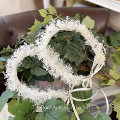 a wreath with white flowers and green leaves