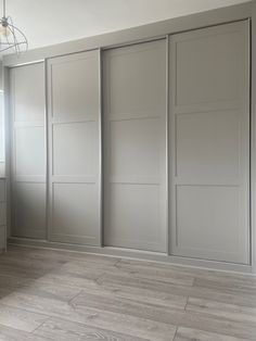 an empty room with sliding doors and wood flooring