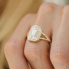 a close up of a person's hand wearing a gold ring with a diamond