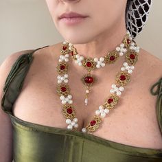 This stunning necklace set, inspired by the Renaissance era, and a portrait of Catherine Howard, is a true work of art. The intricate design features pearls, metal cabochons, and resin gemstones adding a unique and striking touch to any outfit. Crafted by hand, this necklace set is a piece that is sure to impress. With its elegant style and variety of color options , it is perfect for any outfit from Queen to commoner. Add this necklace set to your collection today and make a statement at your n Elegant Gold Costume Jewelry, Elegant Gold Jewelry For Costume, Costume Gold Metal Jewelry, Elegant Handmade Costume Jewelry, Catherine Howard, Tudor Gown, Tudor Style, Queen Mary, Stunning Necklace