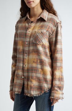 a woman wearing a plaid shirt with fray up sleeves and an oversize button down