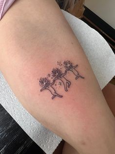 a woman's leg with a tattoo on it that has flowers in the shape of a dog