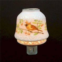 a small white lamp with a bird on it