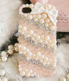 an iphone case with pearls and a bow on it