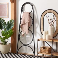 a bathroom with a towel rack, potted plant and other items on the floor