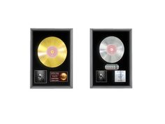 two gold records in a black box with the same disc on each side and an award plaque