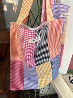 a multicolored tote bag hanging from a rack