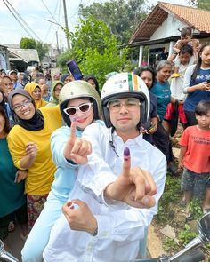 Raffi Ahmad bonceng Nagita Slavina naik Vespa ke TPS 001 Cinere, Depok. Raffi memakai kemeja dan celana pendek putih dan Nagita memakai hoodie biru muda.