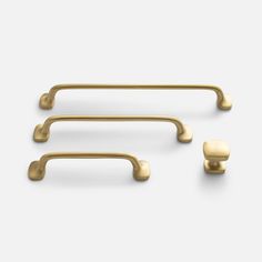 three brass handles and two knobs on a white background