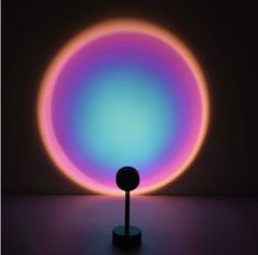 an illuminated object in the middle of a dark room with purple and blue lights on it